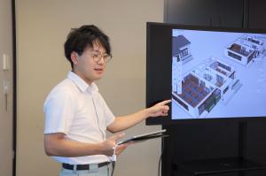 建築技術職　完成図をもとに説明する様子